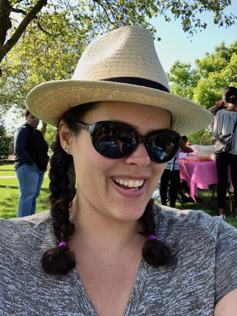 Selfie of woman in hat and sunglasses with braids