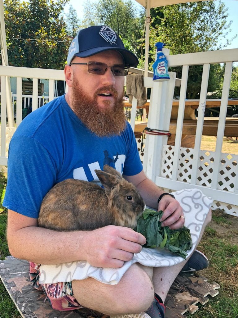 Man Holding Bunny Eating Kale