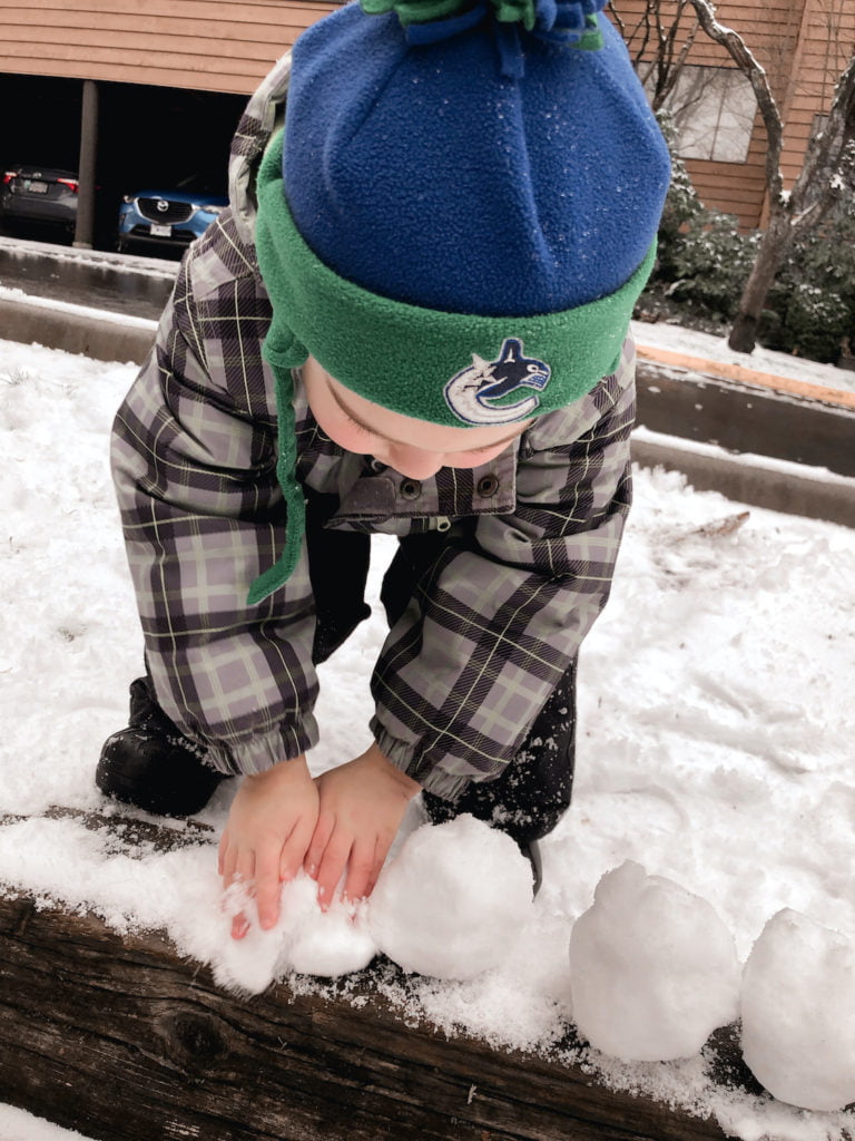 Toddler Playing Bare-Handed with Snowball